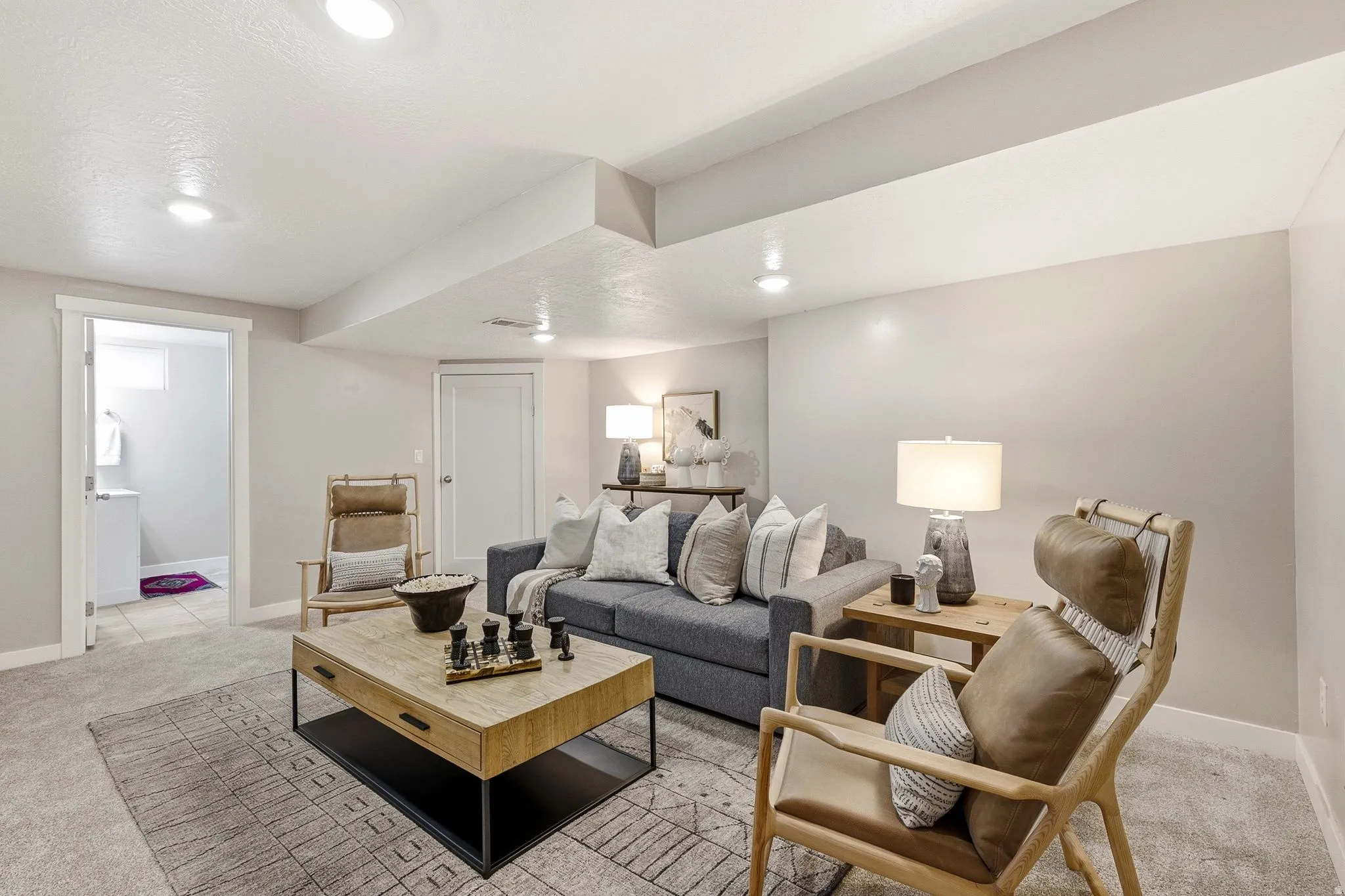 Finished basement recreation room featuring recessed ceiling lighting, neutral wall finishes, and engineered wood-finish flooring