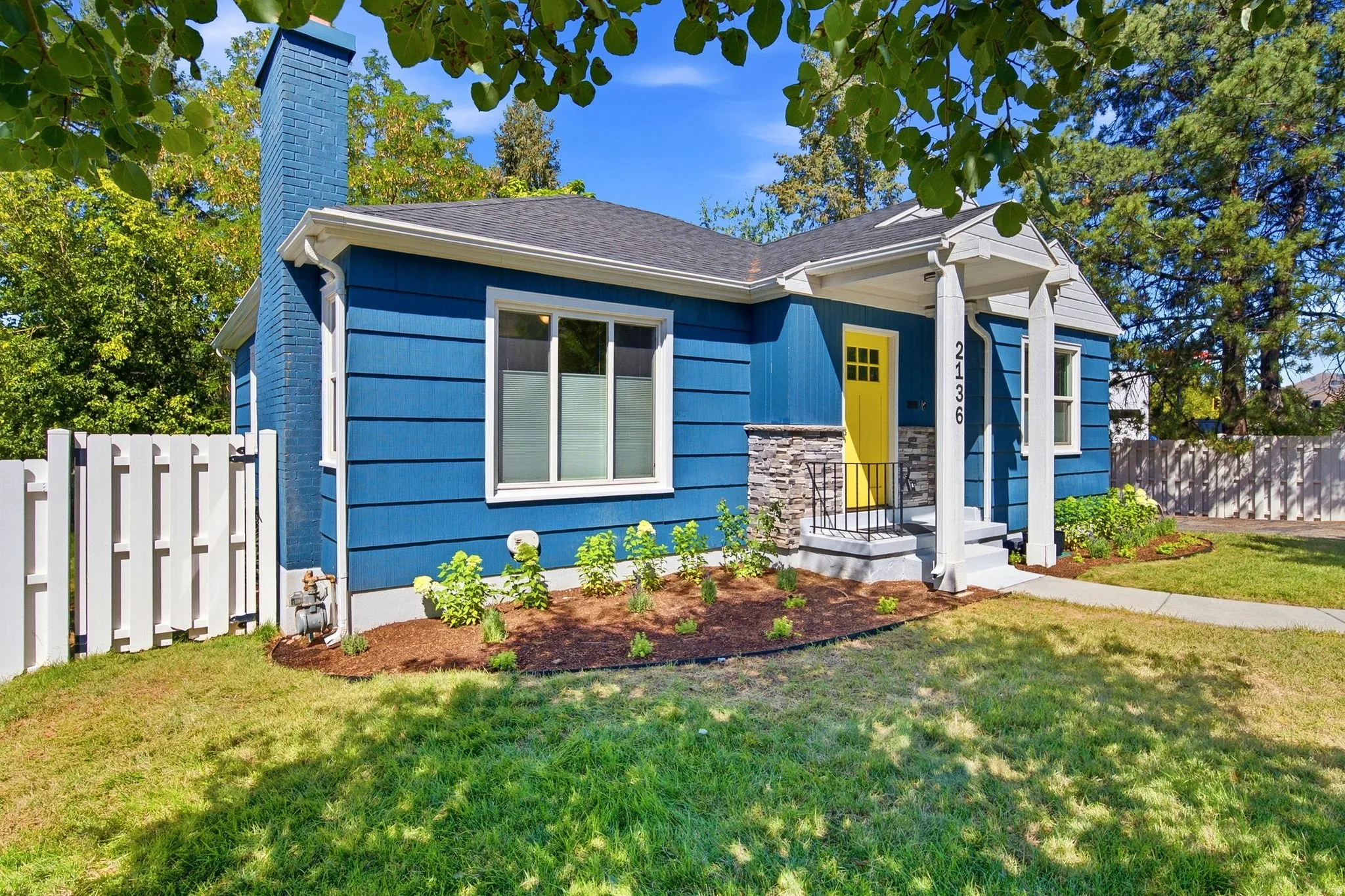Vibrant blue siding exterior with a contrasting yellow entry door