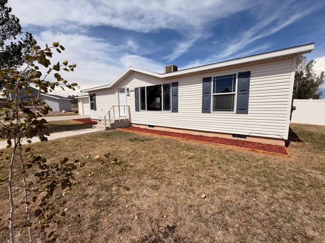 White vinyl siding exterior with dark shutters