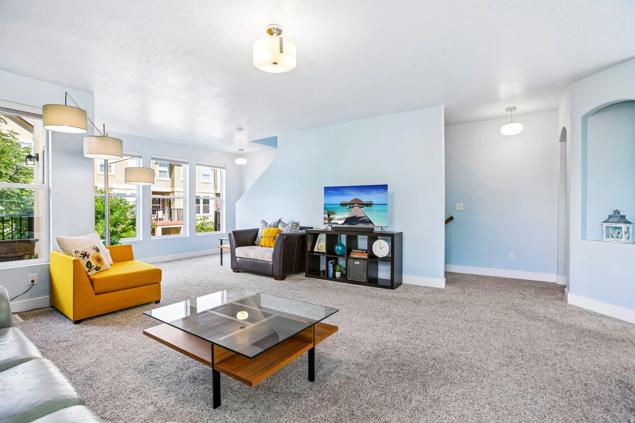 Carpeted living area featuring multiple windows, recessed lighting, and an arched wall niche