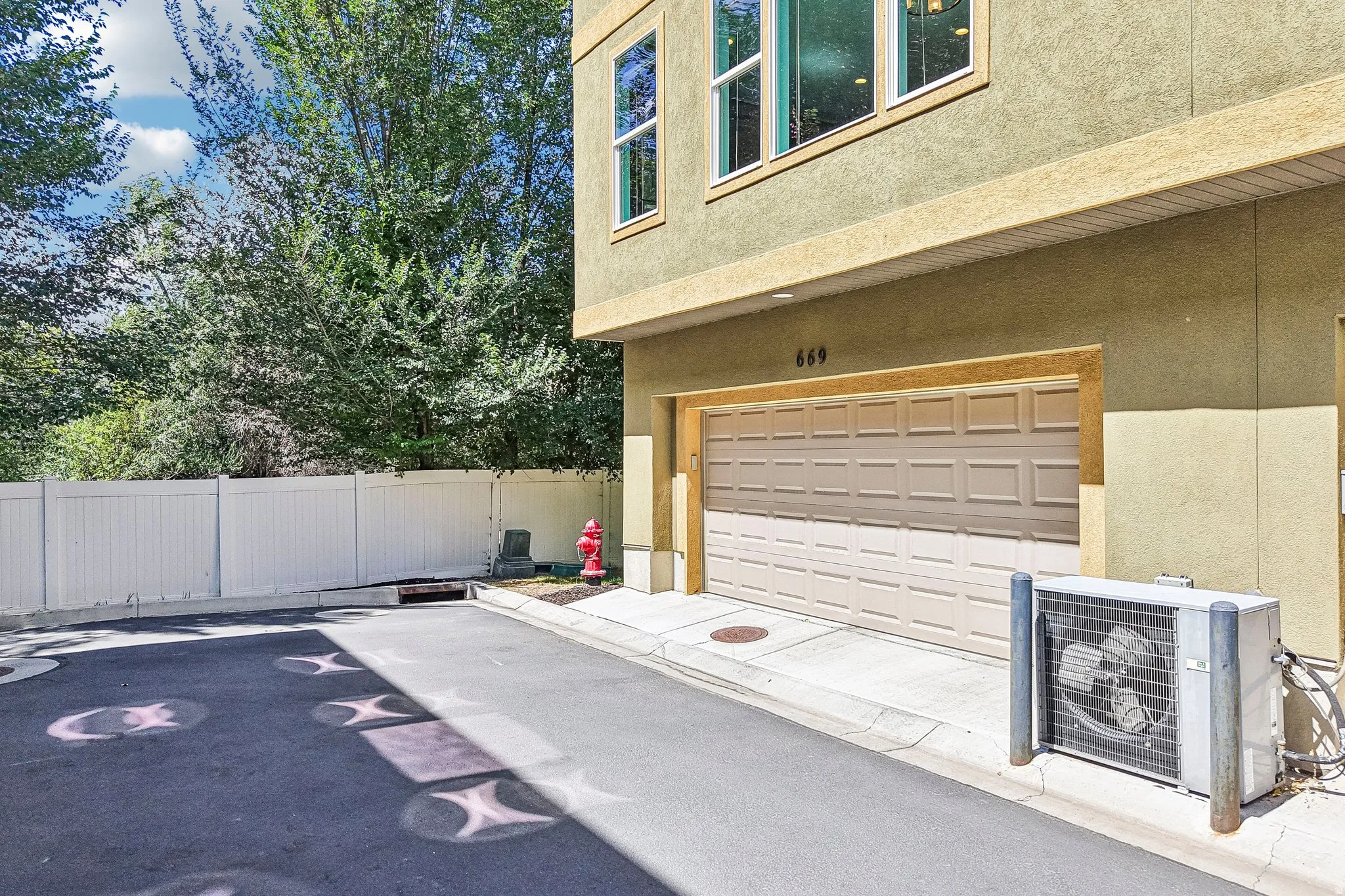 Integrated garage with a panel door, stucco exterior, and multi-pane windows