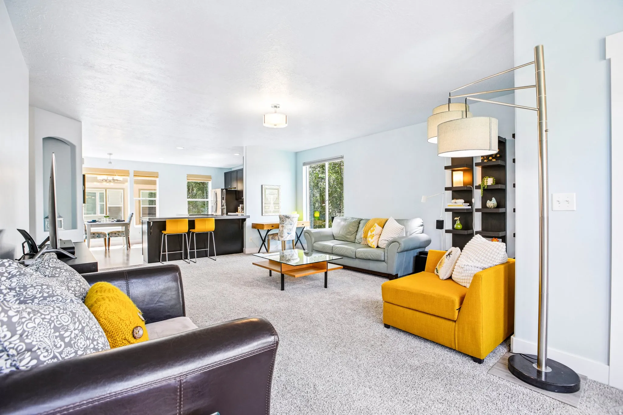 Carpeted living area with recessed lighting, an arched doorway, and built-in shelving
