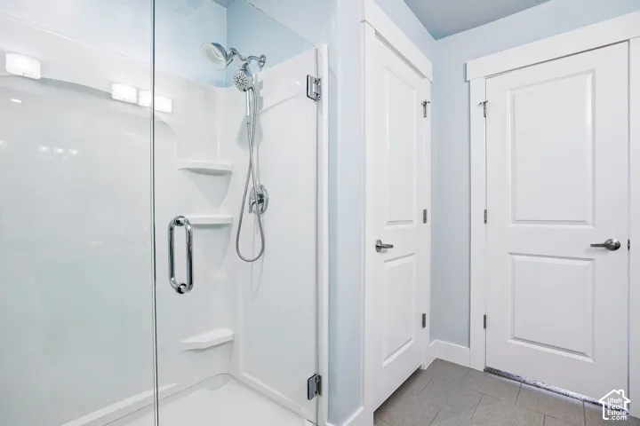 Spa-inspired primary bathroom featuring a frameless glass-enclosed shower with dual showerheads, white subway tile surround, built-in niches, and polished chrome fixtures
