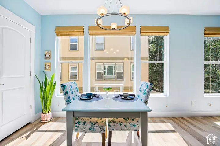 Bright dining area flooded with natural light through multiple multi-pane windows with gold-toned Roman shades