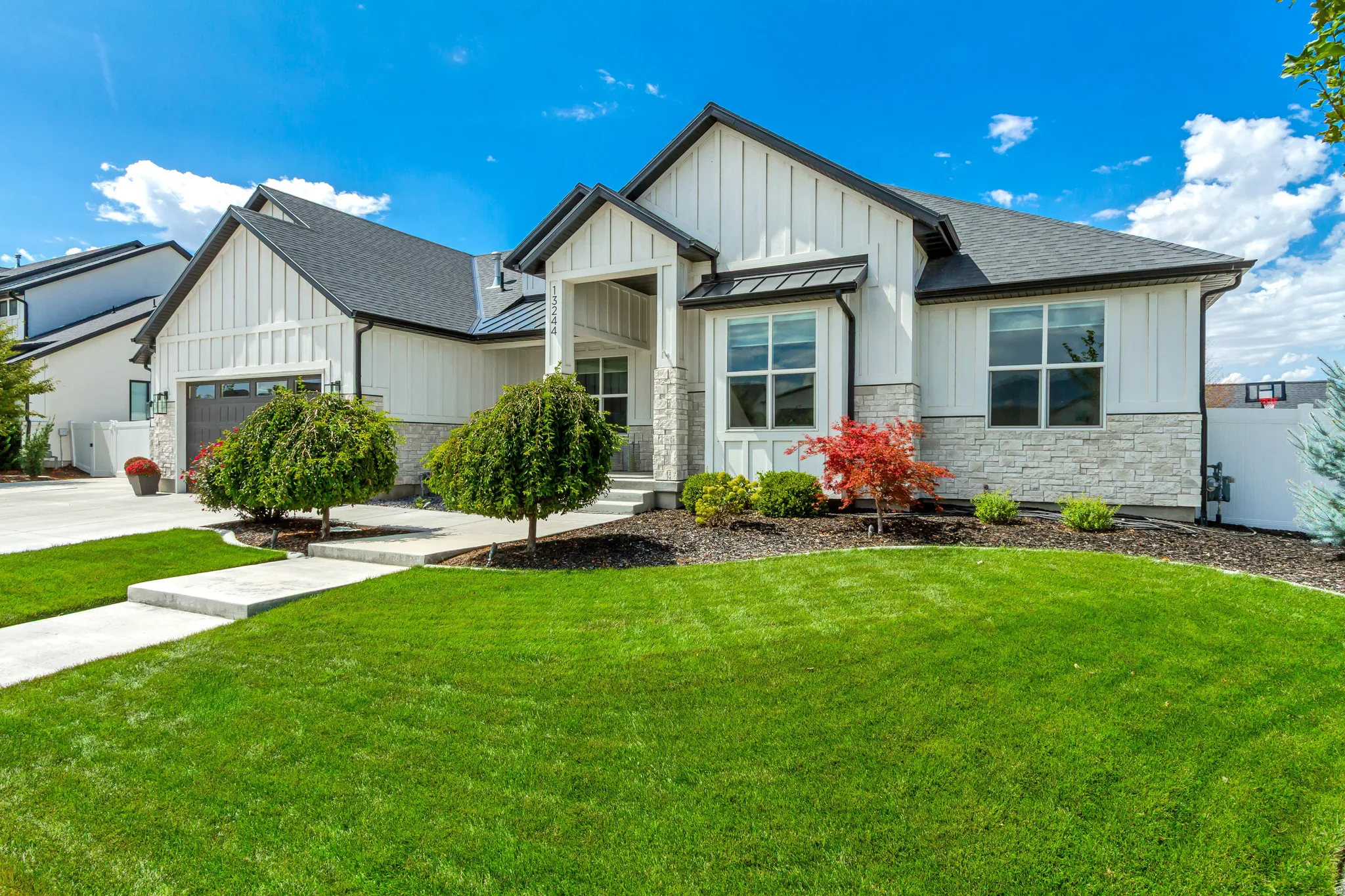 Exterior featuring board and batten siding, stone accents, and a dark shingle roof