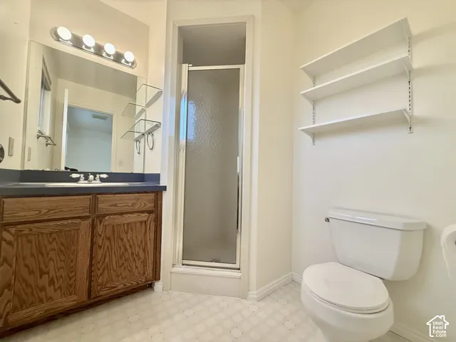 Bathroom vanity with wood-finish cabinetry, a single sink, and an overhead light bar