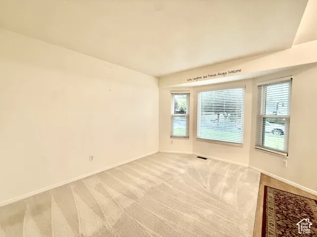 Bay window with multiple panels, neutral tone carpet, and light-colored walls