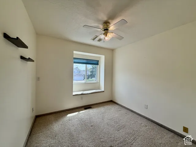 Recessed window with a built-in window seat, ceiling fan, and wall-mounted shelving