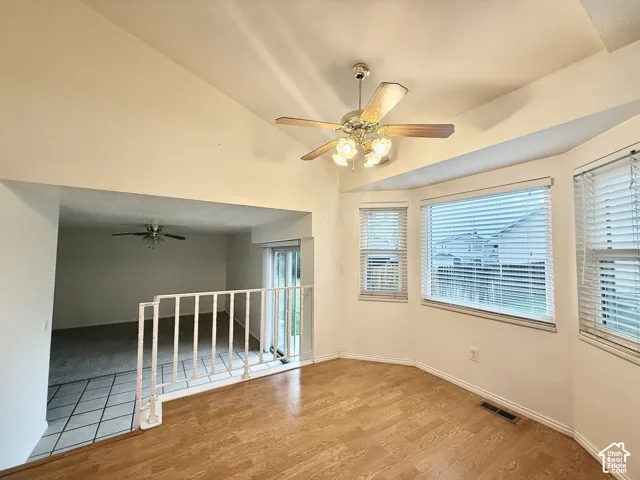 Vaulted ceiling featuring a ceiling fan with integrated lighting