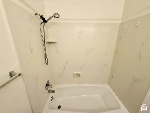 Bathtub with a shower/tub combination, wall-mounted showerhead, and integrated soap dish