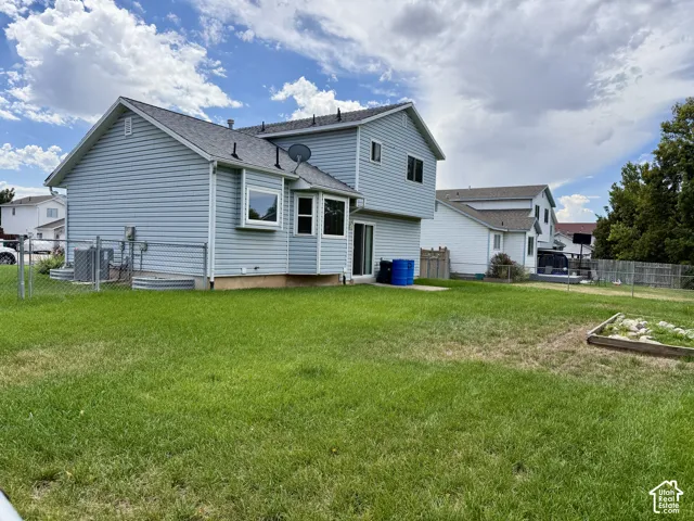 Expansive lawn area with a raised garden bed and chain-link fencing