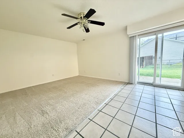 Sliding glass door, tiled flooring, carpeted flooring, ceiling fan, neutral wall tones