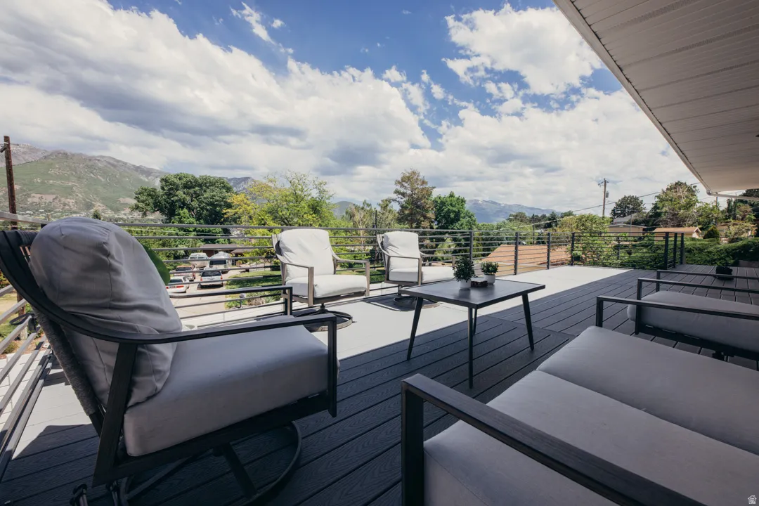 Expansive rooftop deck featuring composite decking, contemporary lounge seating areas, and multiple dining surfaces with metal framing
