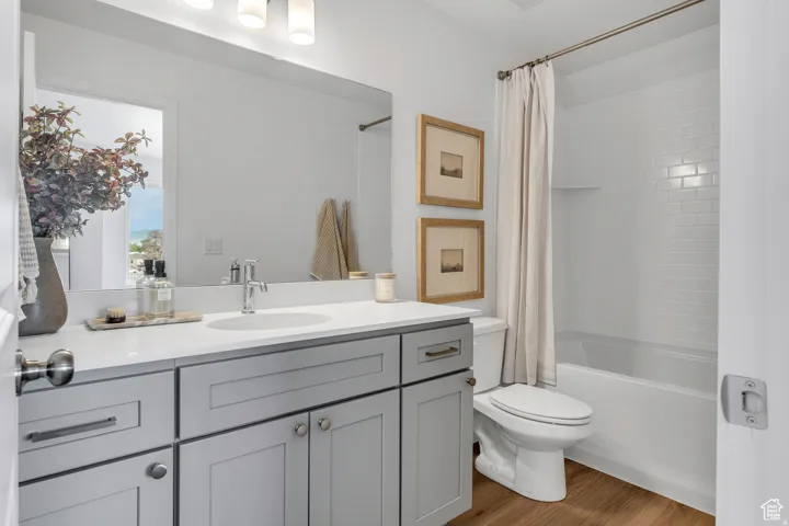 Spa-inspired primary bathroom featuring a double vanity with ample storage, white quartz countertop, chrome fixtures, and a walk-in shower with subway tile surround and frameless glass enclosure