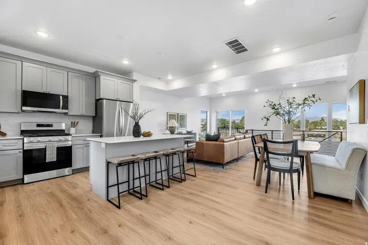 Open-concept floor plan featuring wood-finish flooring, recessed lighting, and large windows