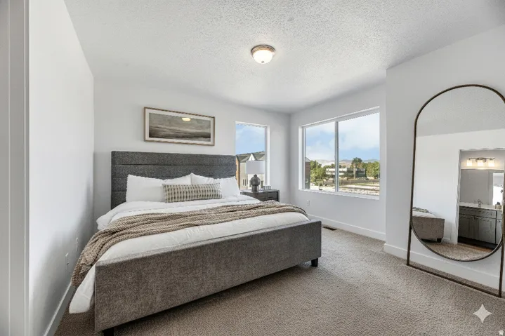 Carpeted bedroom featuring large windows, a ceiling-mounted light fixture, and a built-in vanity with a sink and mirror