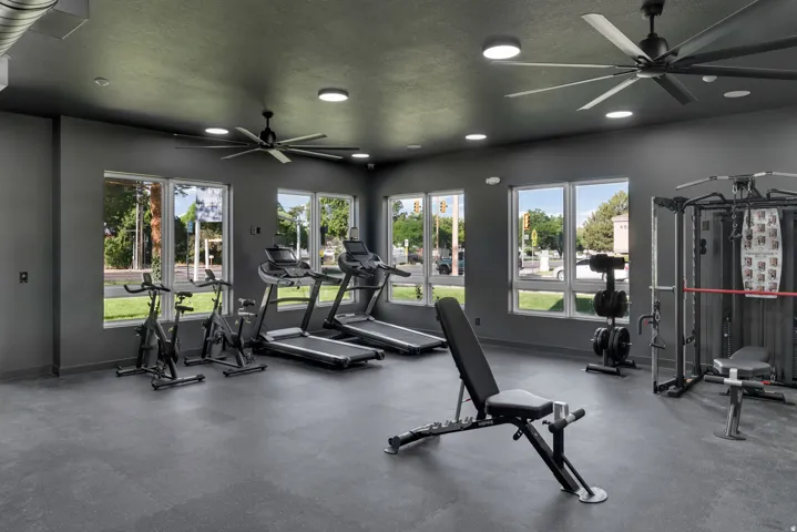 Fitness center featuring large windows, recessed lighting, and rubber flooring