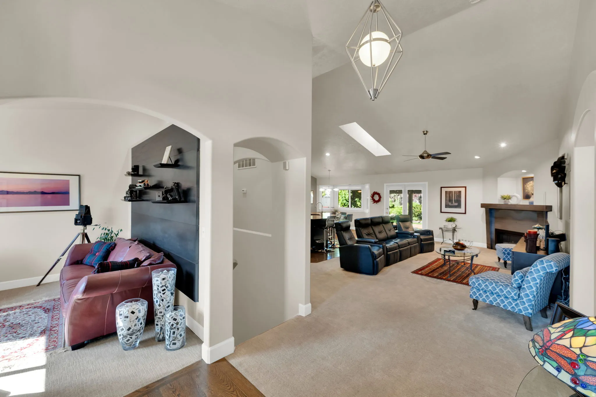 Vaulted ceilings, recessed lighting, skylight, fireplace with mantel, and arched doorways