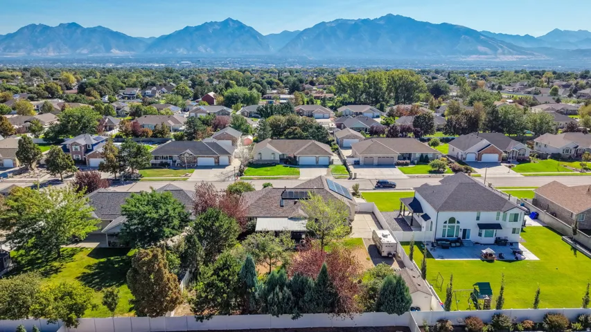 Expansive neighborhood setting with mature trees and mountain backdrop