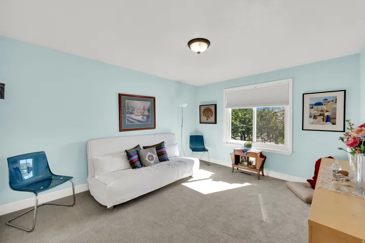 Carpeted flooring, single pane window, light blue wall paint, white trim, and a flush mount ceiling light