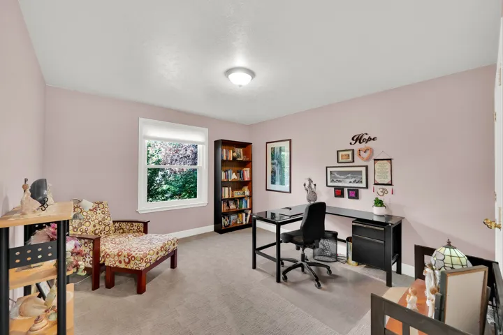 Neutral wall color, window with white trim, recessed lighting, built-in shelving, and carpeted flooring