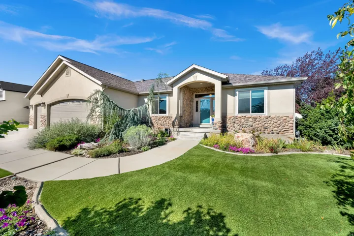 Contemporary ranch-style residence showcasing a stucco and stone exterior with a two-car garage