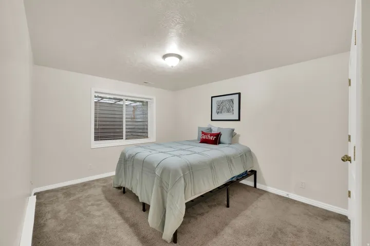 Neutral-toned walls with recessed window, overhead flush-mount lighting, and carpeted flooring