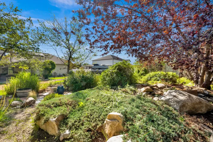 Landscaped grounds featuring natural rock elements and mature trees