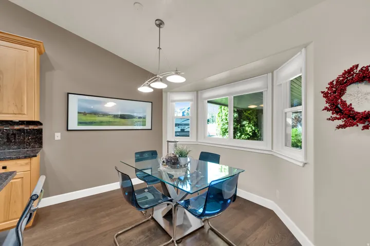 Hardwood flooring with a bay window, recessed lighting, and a contemporary chandelier