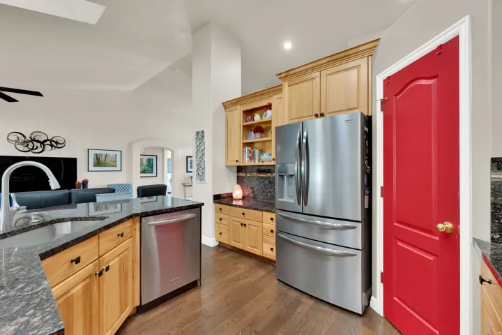 Contemporary kitchen featuring custom wood cabinetry, stainless steel French-door refrigerator, and stainless steel dishwasher