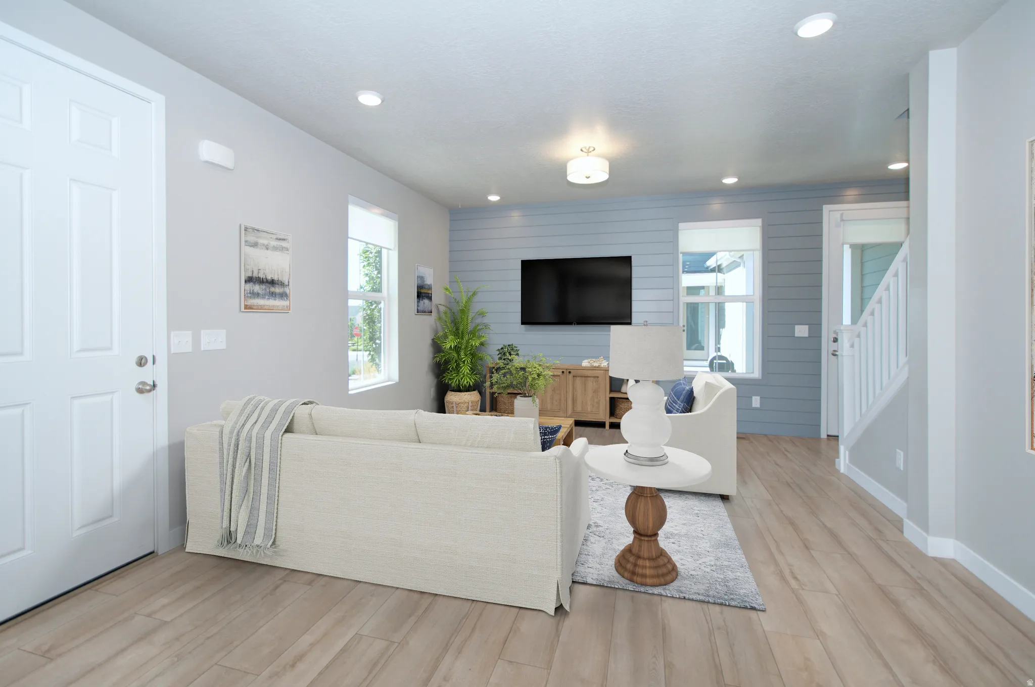 Open-concept living rear featuring wood-finish flooring, recessed lighting, white trim, and a shiplap accent wall