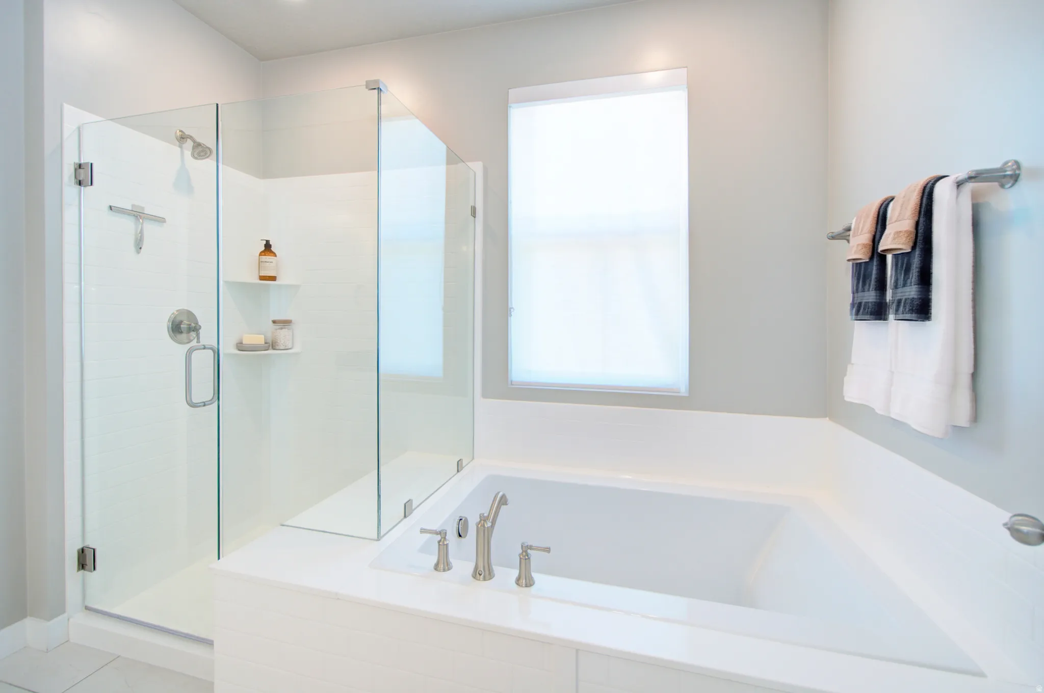 Walk-in shower with clear glass enclosure and built-in shelving