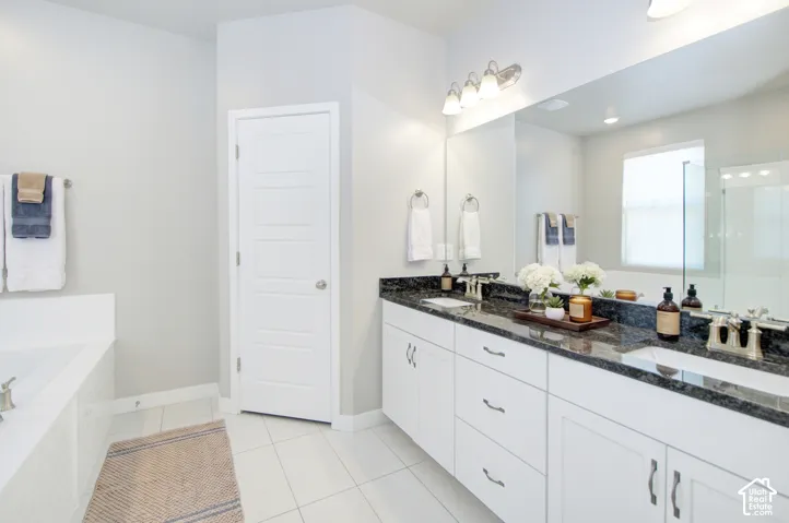 Dual vanity with dark stone countertop, undermount sinks, and white cabinetry