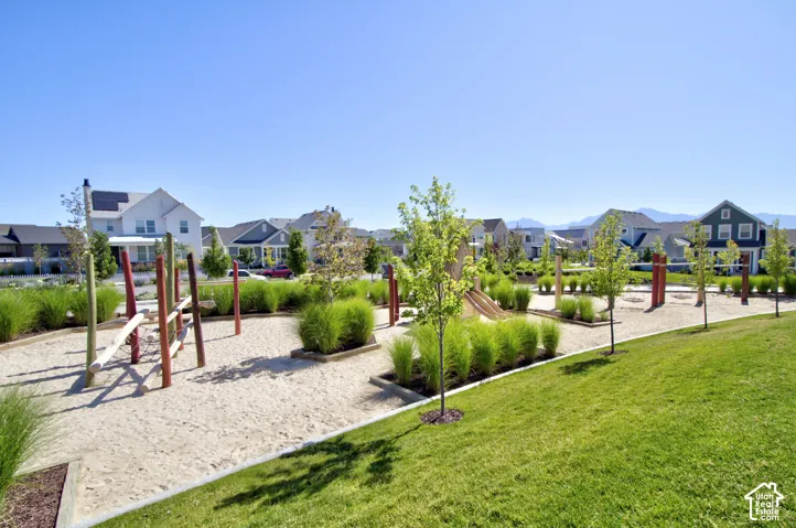 Expansive outdoor recreational space featuring a sand play area, climbing structures, and a slide