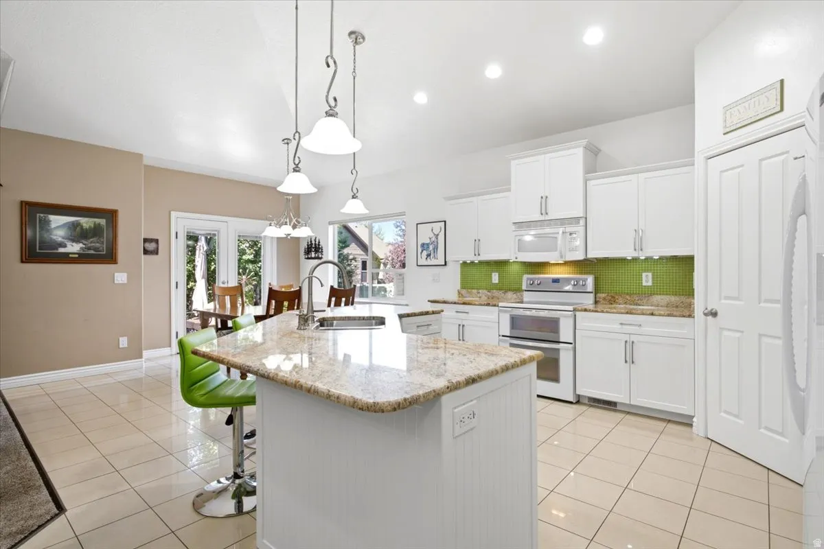 The upgraded kitchen features white shaker skyline cabinetry, granite countertops, a tile backsplash, under-cabinet lighting, and soft-close doors and drawers.
