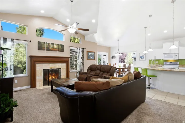 Vaulted ceilings, abundant natural light, and a gas fireplace create an inviting main living area that opens to the upgraded kitchen.