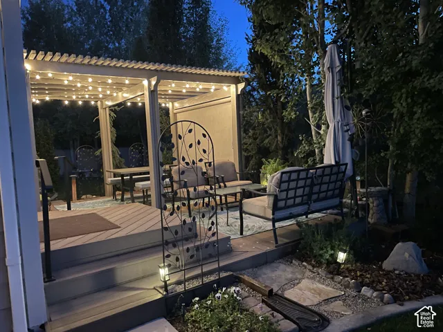 Pergola-covered outdoor deck with built-in string lighting