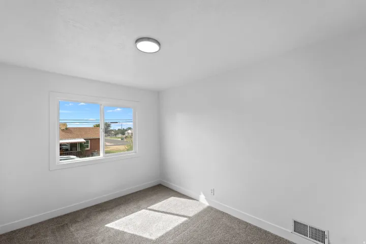 Crisp white walls with gray carpet flooring