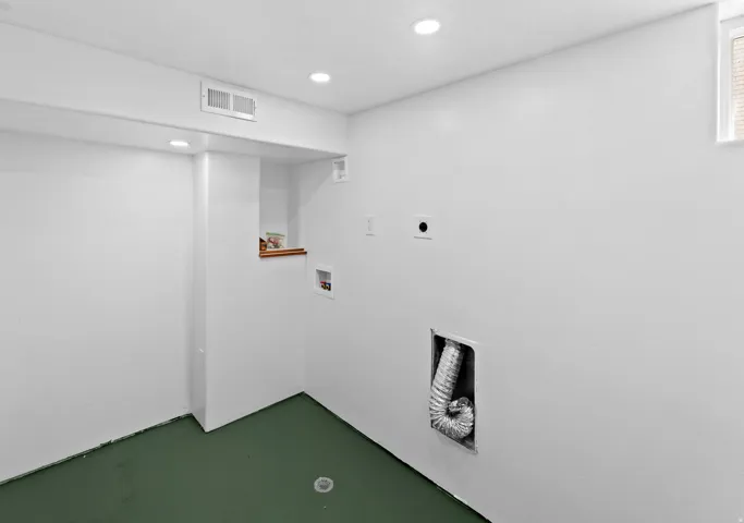 White painted walls with recessed lighting and a green floor