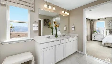 Dual vanity with integrated sinks, white cabinetry, and a large mirror