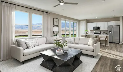 Open-concept living space featuring wood-finish flooring, recessed lighting, a ceiling fan, and sliding glass doors