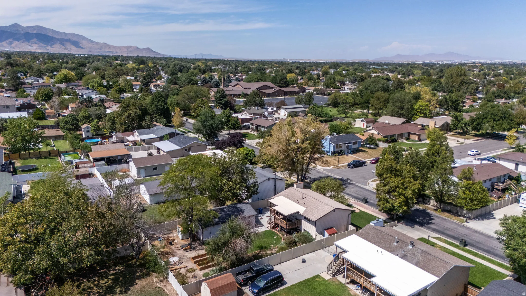 Suburban neighborhood with mature trees and mountain backdrop