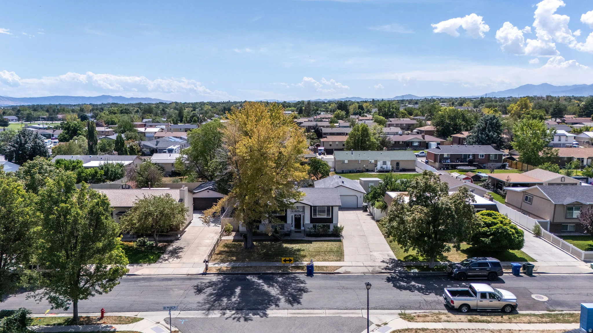 Neighborhood setting with established trees and mountain backdrop