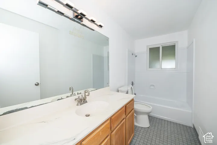 Bathroom vanity with an integrated sink, brushed nickel faucet, and a large wall-mounted mirror