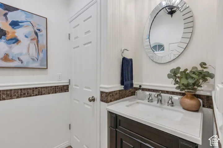 Vanity with integrated sink, polished chrome faucet, and dark wood cabinetry