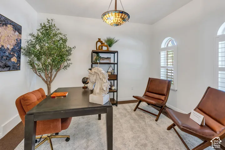 Arched windows with plantation shutters, a decorative ceiling light fixture, and wood-finish flooring