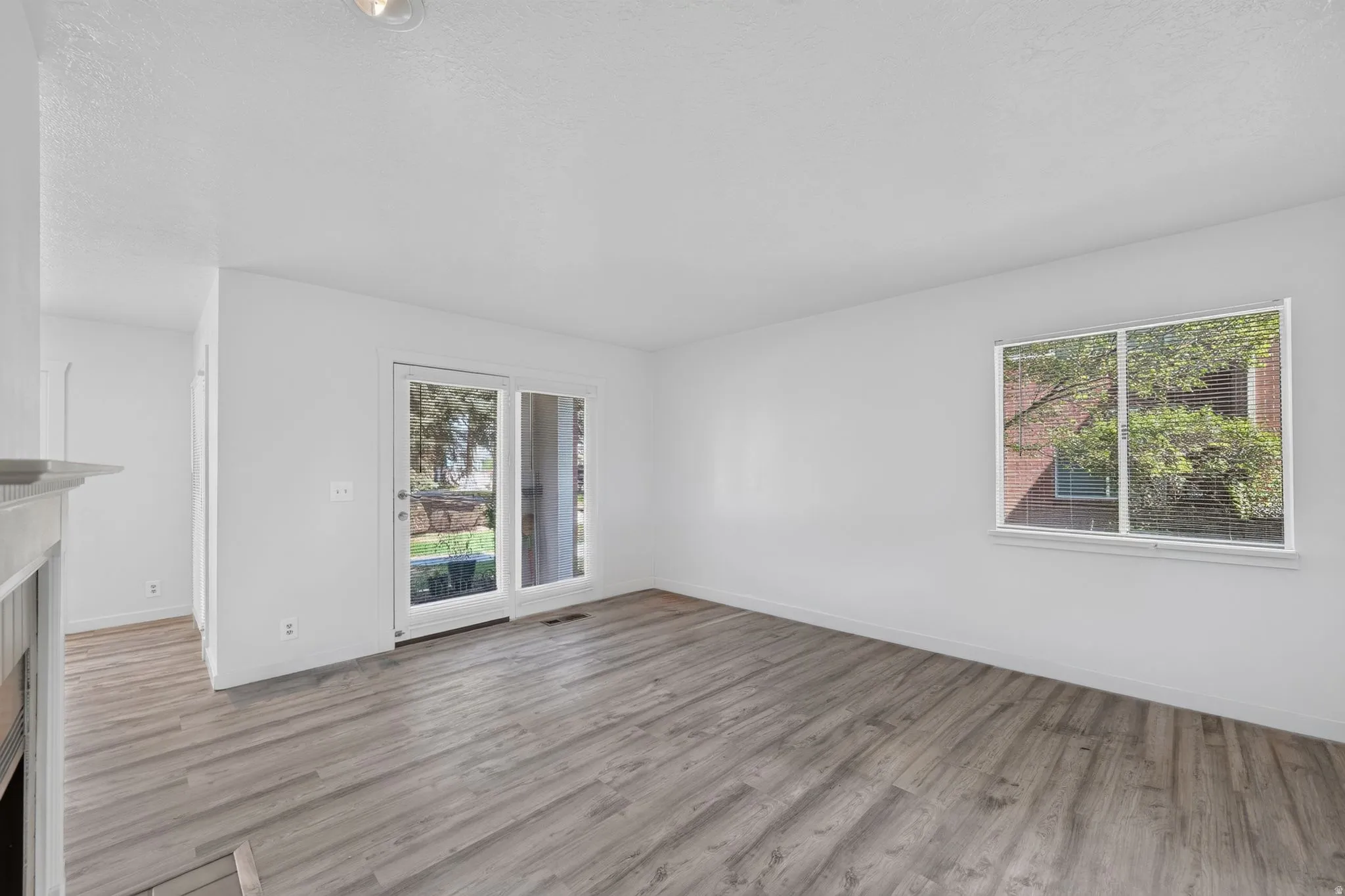 Wood-finish flooring, white walls, double pane window, and glass panel door