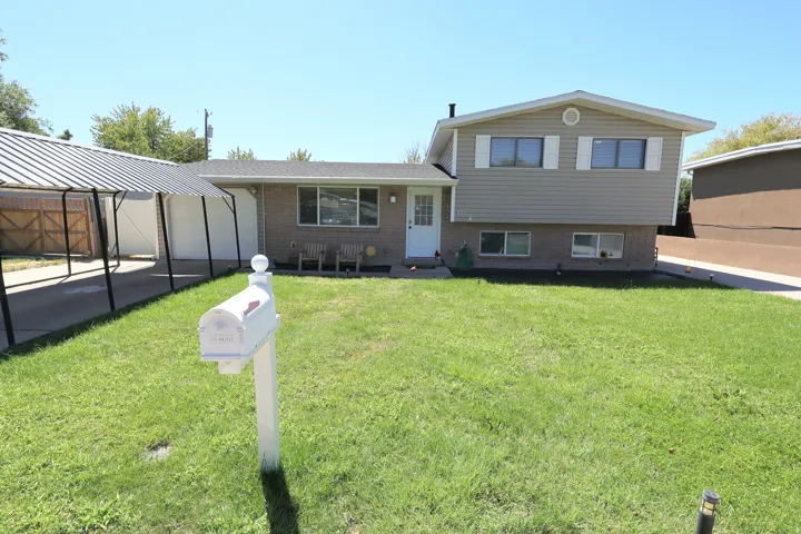 Split-level exterior featuring brick and horizontal siding