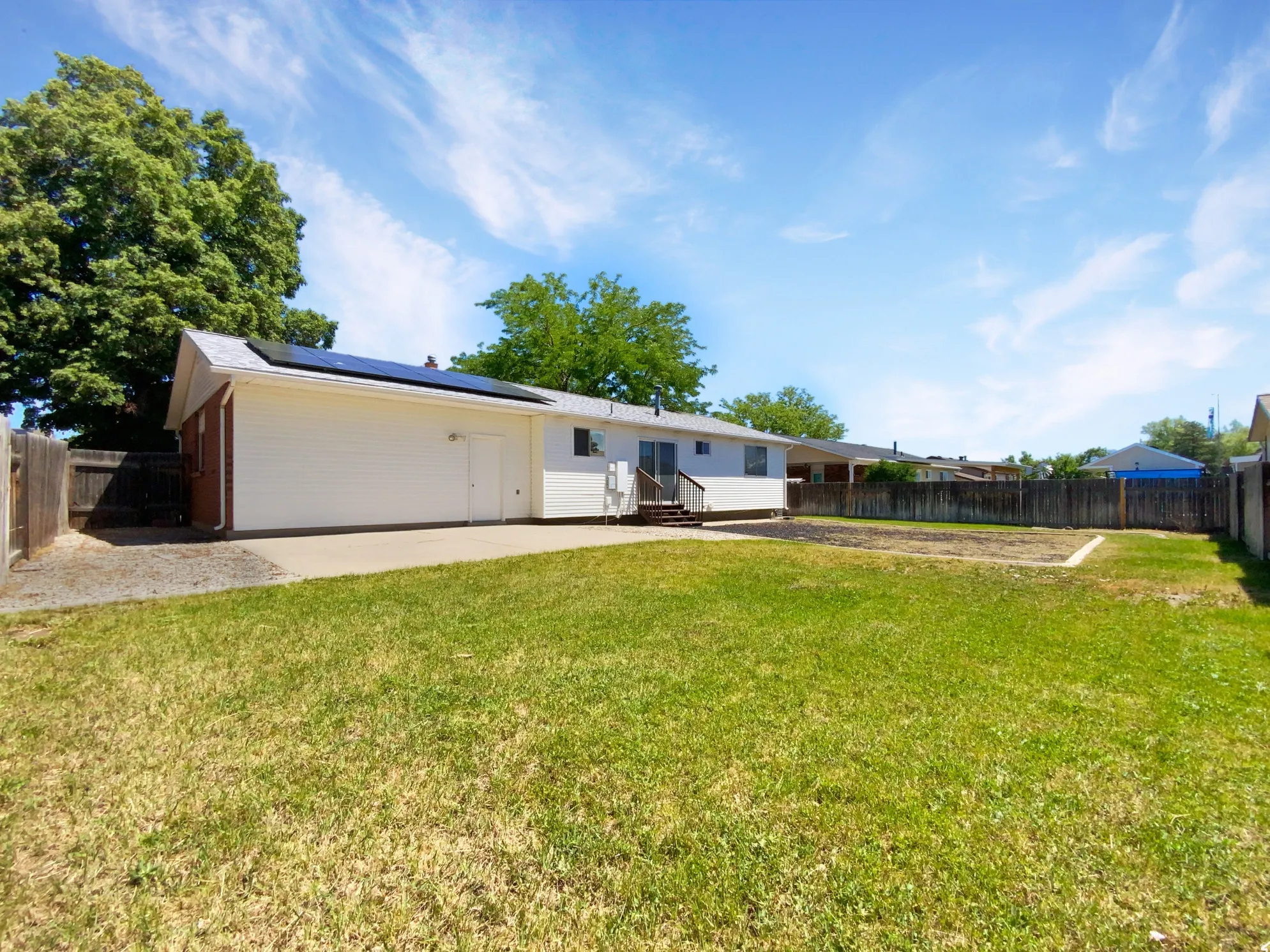 Previous picture: Expansive grass backyard with wood fencing and concrete patio