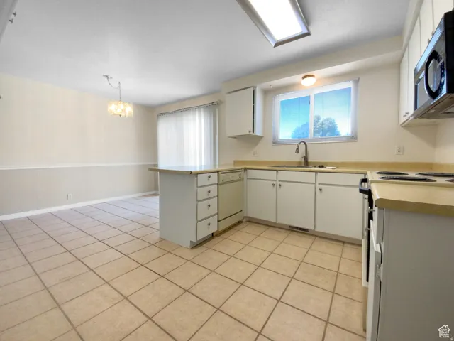 Previous picture Kitchen featuring white cabinetry, light-colored countertops, a stainless steel sink, and tile flooring